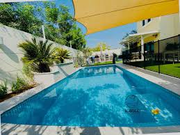 Modern villa swimming pool in Jumeirah Park with landscaped garden and sun loungers